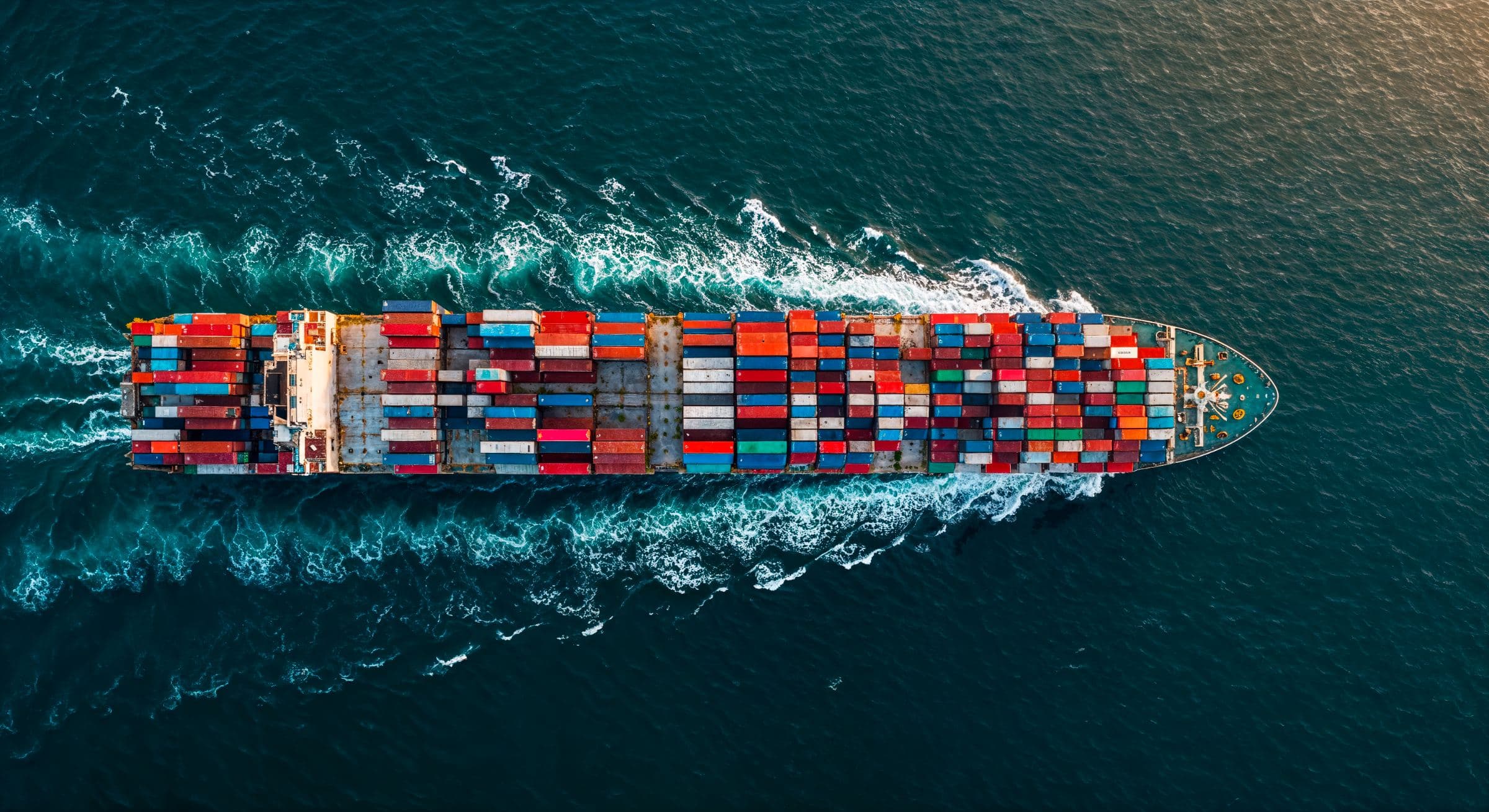 Container ship crossing open ocean, seen from above